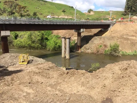 Bridge and retaining structure civil works over a stream.